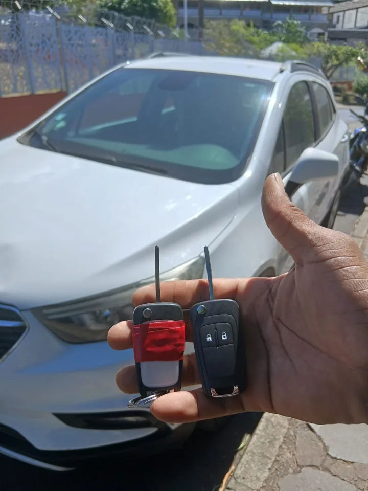 Deux clés présentées devant un monospace Ford, dont une avec une coque maintenue par un adhésif. — AttoVa Service, Mayotte.