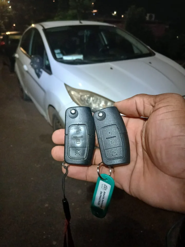 Deux clés à télécommande présentées devant une voiture Ford blanche. — AttoVa Service, Mayotte.
