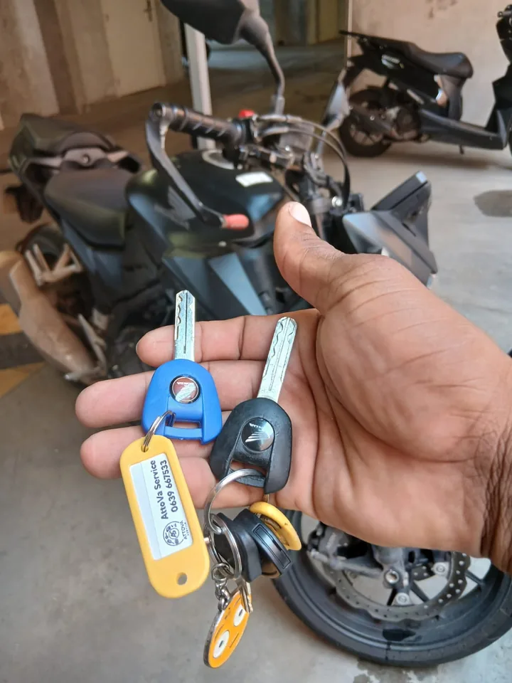 Deux clés présentées devant une moto Honda, avec un porte-clés AttoVa Service. — AttoVa Service, Mayotte.