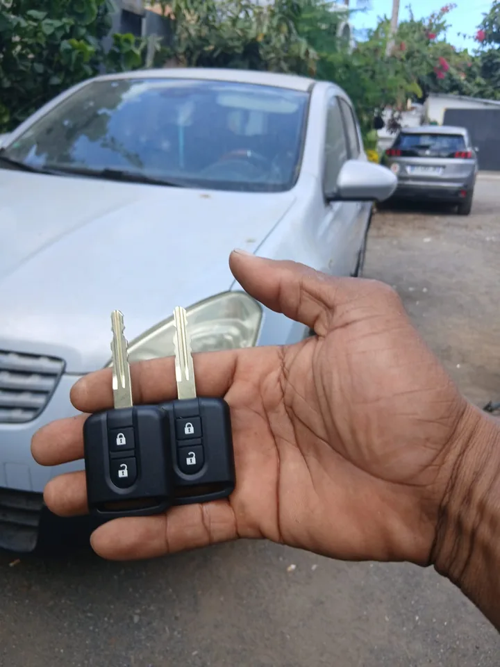 Deux clés de voiture présentées devant un véhicule Nissan. — AttoVa Service, Mayotte.