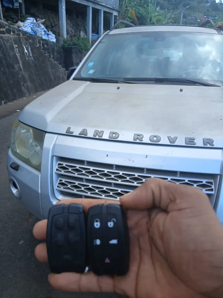 Deux télécommandes présentées devant un véhicule Land Rover. — AttoVa Service, Mayotte.