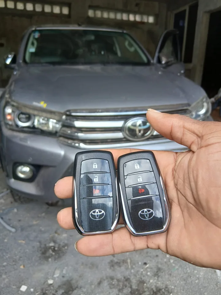 Deux télécommandes Toyota présentées devant un véhicule de la marque. — AttoVa Service, Mayotte.
